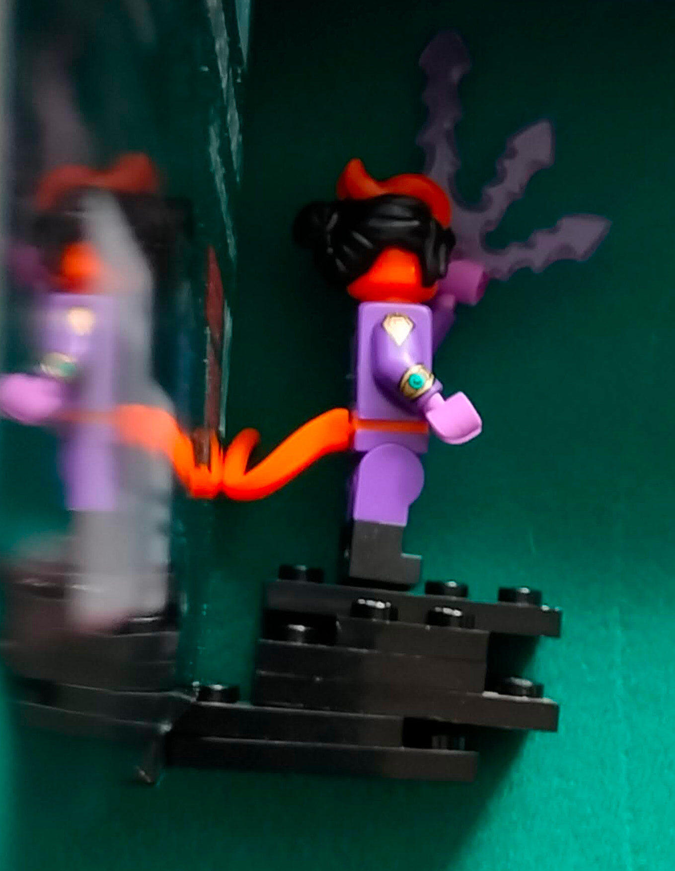 The Tiefling figure with it's tail just touching the backing